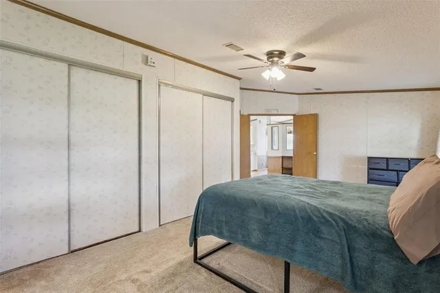 a bedroom with a bed and a ceiling fan