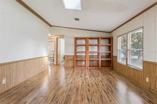 a view of empty room with wooden floor and windows