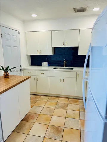 a kitchen with a sink a stove top oven and cabinets