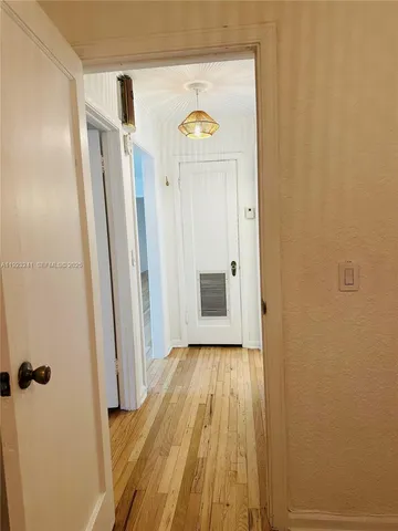 a view of a room with wooden floor and a window
