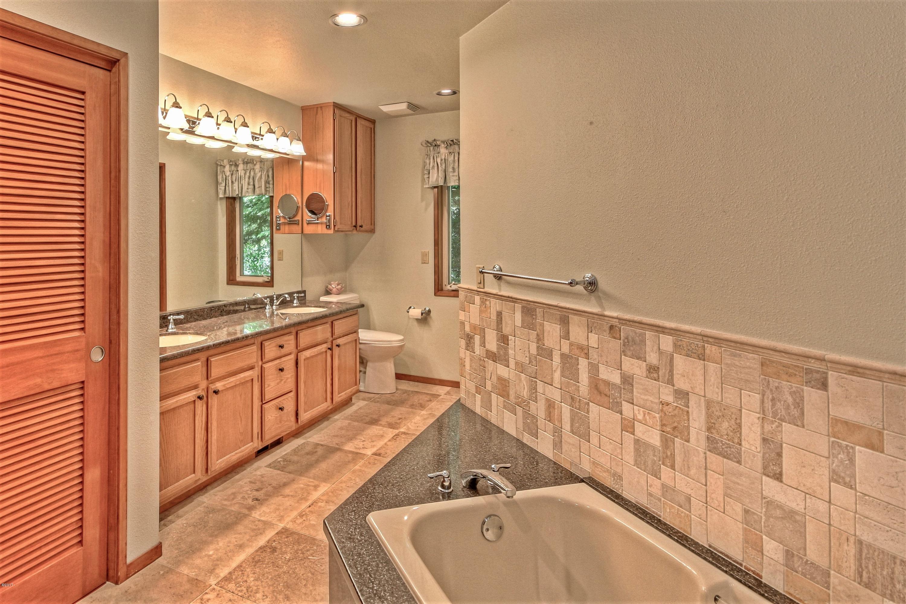 17 Big Tree Road Gleneden Beach, OR 97388 - Photo 22 of 52 a spacious bathroom with a tub sink and mirror