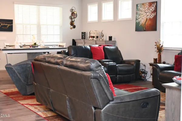 a living room with furniture a flat screen tv and a window