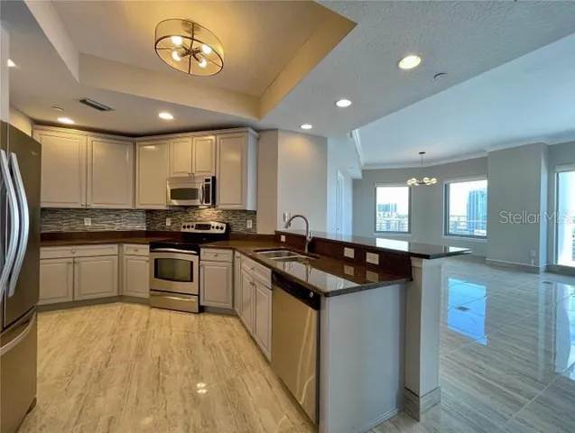 a view of a kitchen with a sink and refrigerator