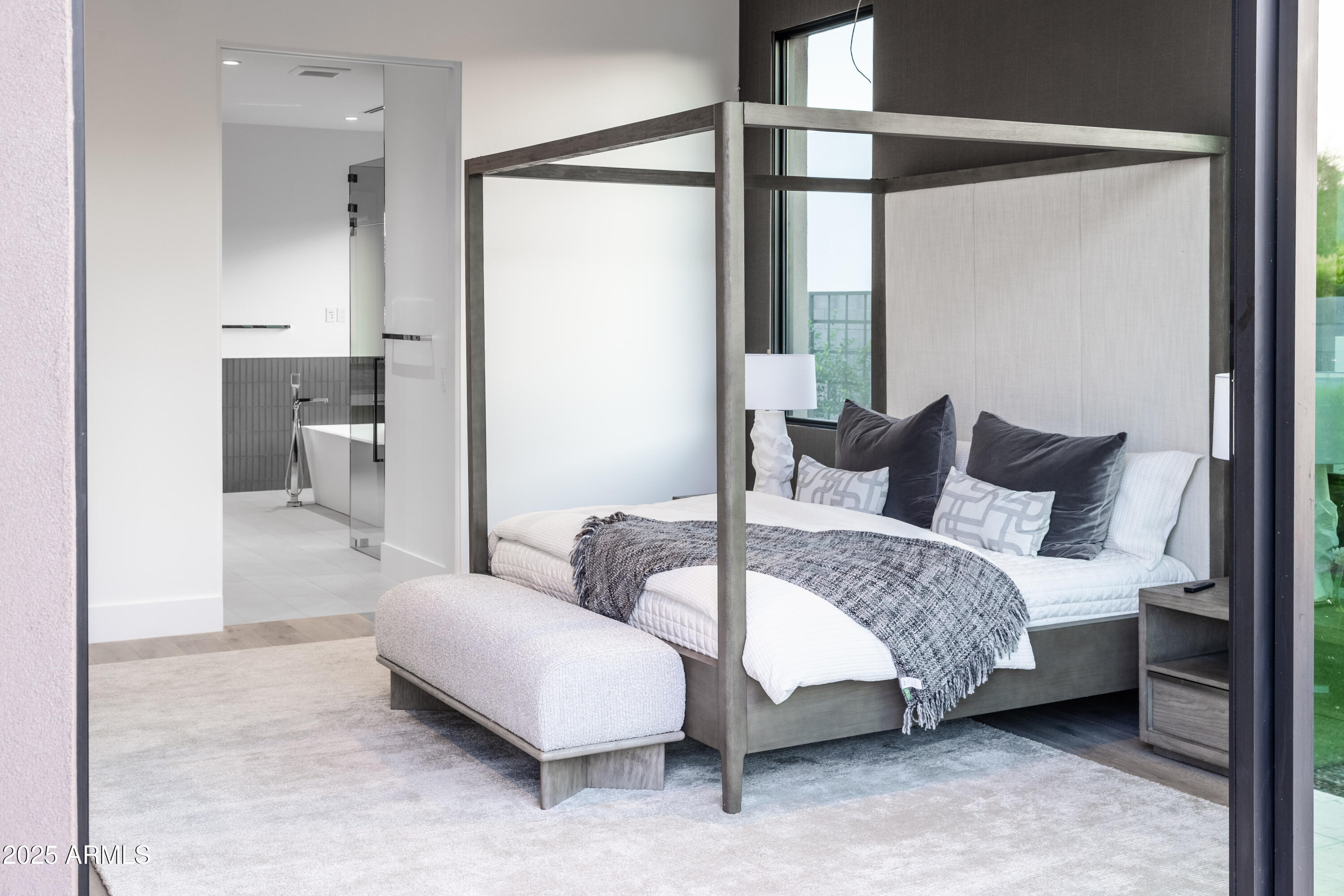 6850 East Joshua Tree Lane Paradise Valley, AZ 85253 - Photo 20 of 39 a spacious bedroom with a bed and a couch