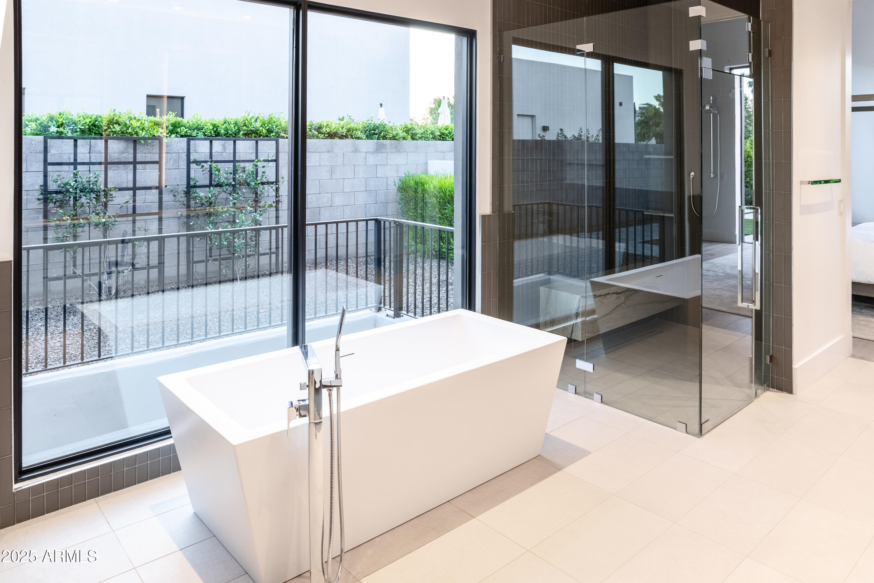 6850 East Joshua Tree Lane Paradise Valley, AZ 85253 - Photo 21 of 39 a white bath tub sitting in front of a glass door