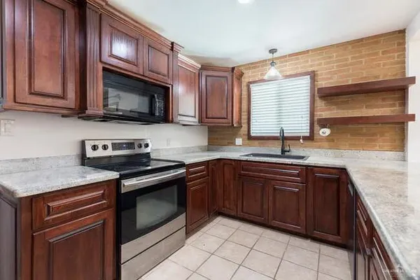 a kitchen with granite countertop stainless steel appliances and wooden cabinets