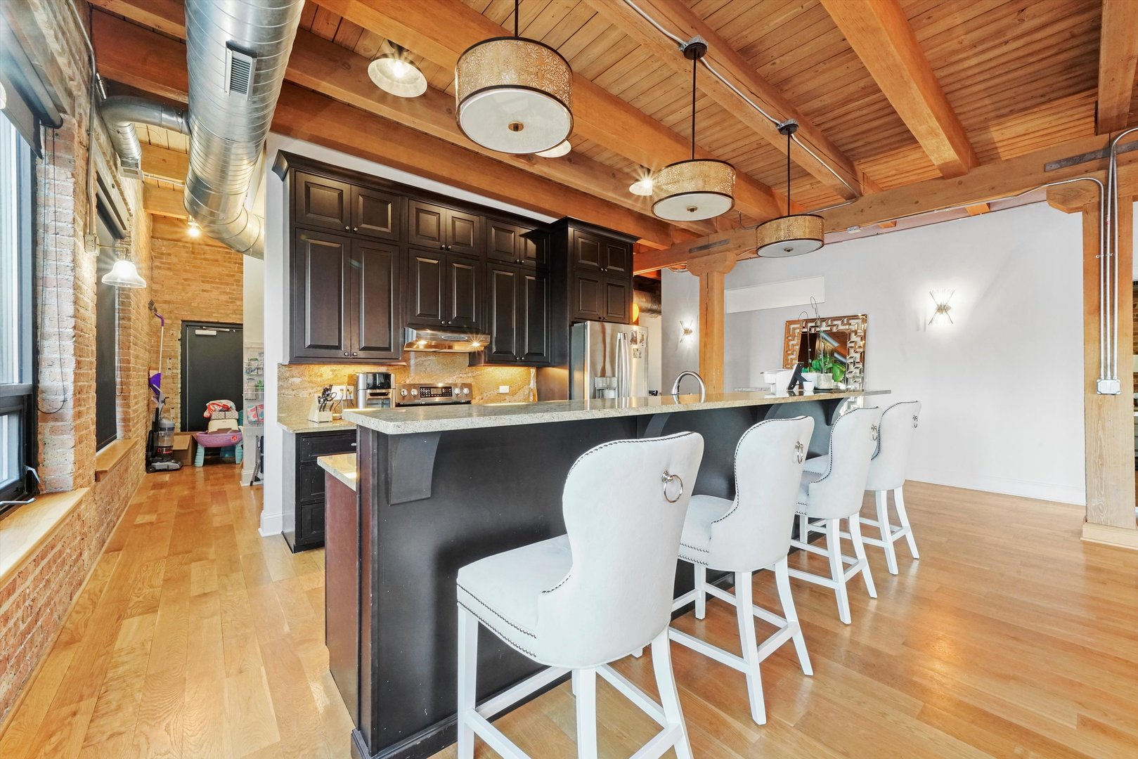935 West Randolph Street, Unit PH Chicago, IL 60607 - Photo 6 of 35 a dining area with stainless steel appliances kitchen island granite countertop a table chairs and a view of living room