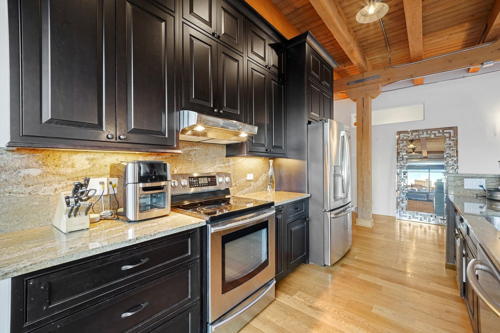 935 West Randolph Street, Unit PH Chicago, IL 60607 - Photo 10 of 35 a kitchen with stainless steel appliances granite countertop a stove and a refrigerator