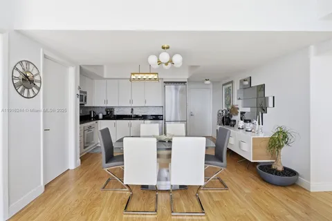 a living room with furniture a rug and kitchen view