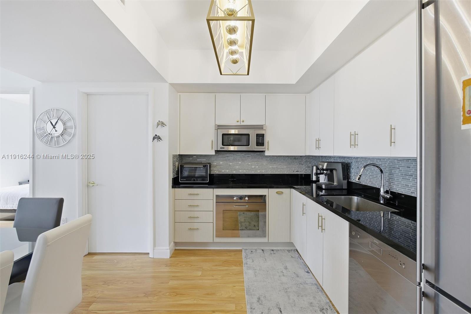 92 Southwest 3rd Street, Unit 1604 Miami, FL 33130 - Photo 16 of 53 a kitchen with granite countertop a sink stove and cabinets