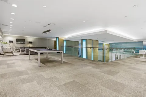 a room with pool table and windows