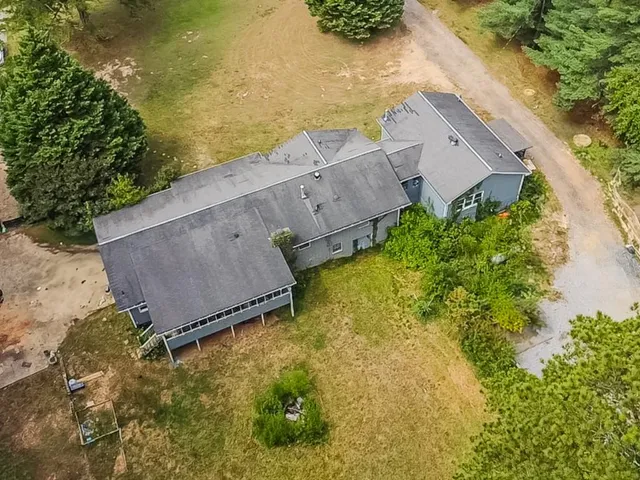 an aerial view of house with yard and ocean view