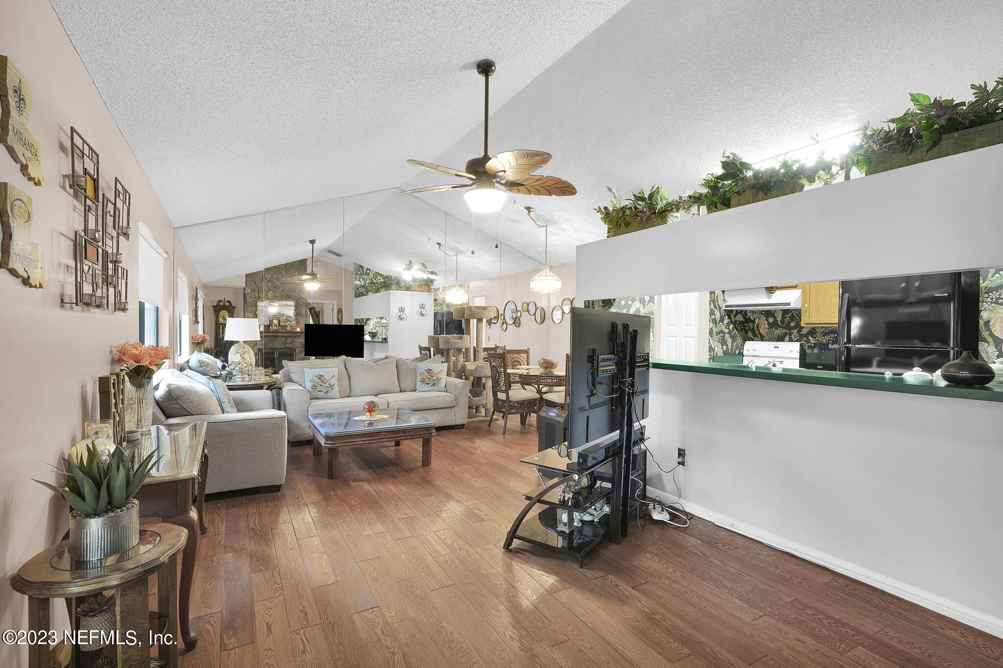 10250 Lake Pines Road Jacksonville, FL 32257 - Photo 6 of 24 a living room with couches a fireplace and kitchen view with wooden floor