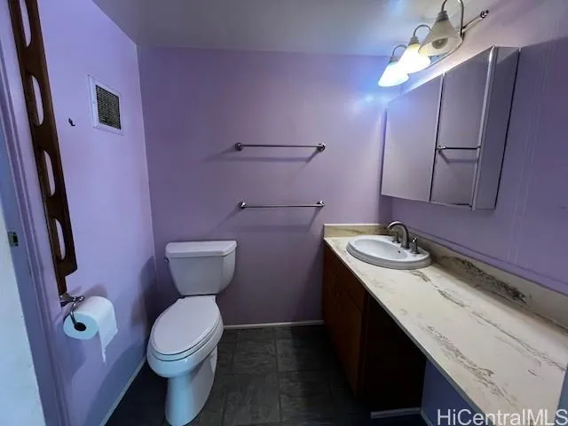 a bathroom with a sink mirror vanity and toilet