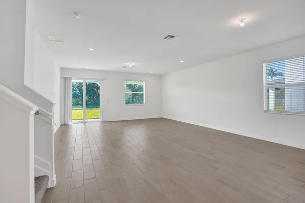 an empty room with wooden floor and glass door