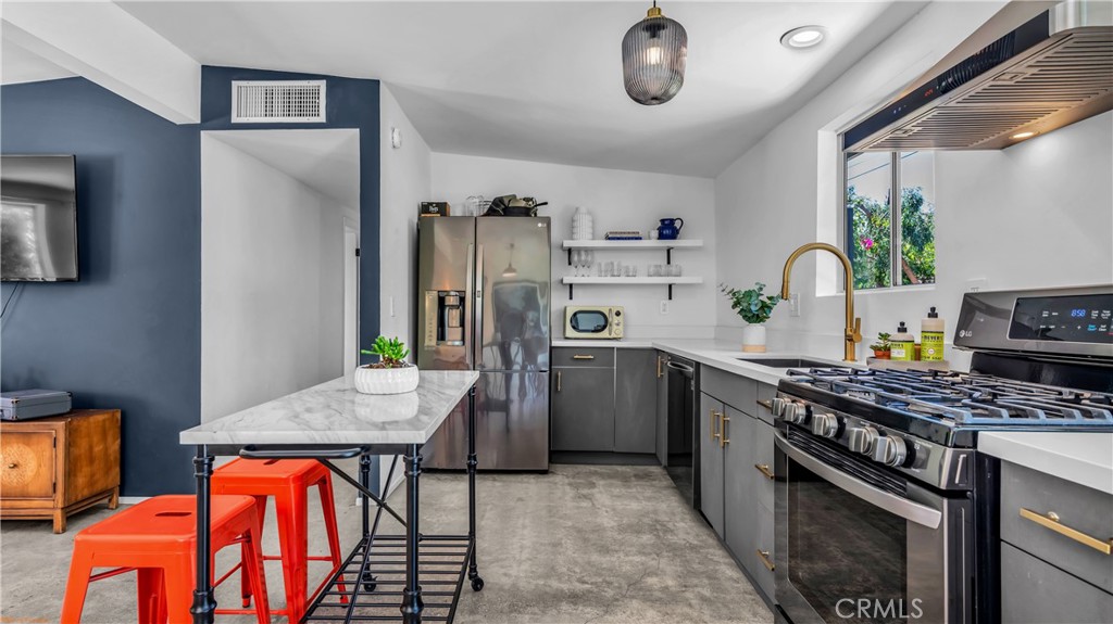 250 West Cortez Road Palm Springs, CA 92262 - Photo 12 of 54 a kitchen with stainless steel appliances granite countertop a stove refrigerator sink and cabinets