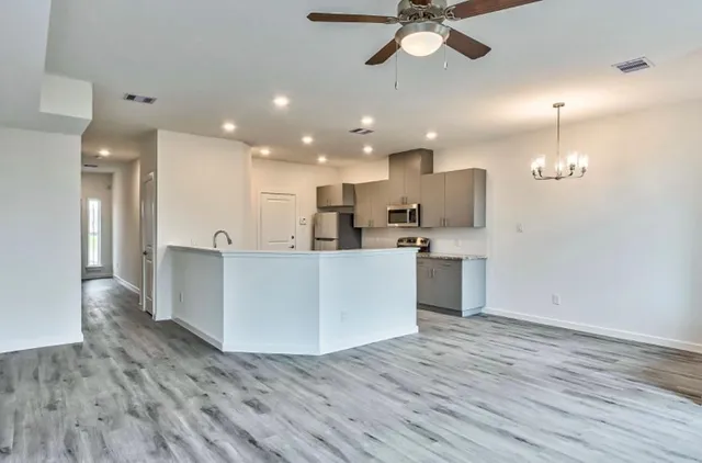 a view of kitchen with kitchen island wooden floor center island and appliances