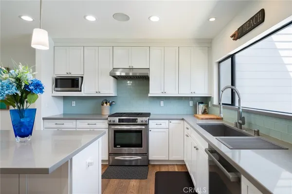 a kitchen with stainless steel appliances granite countertop a stove top oven a sink a counter top space and cabinets