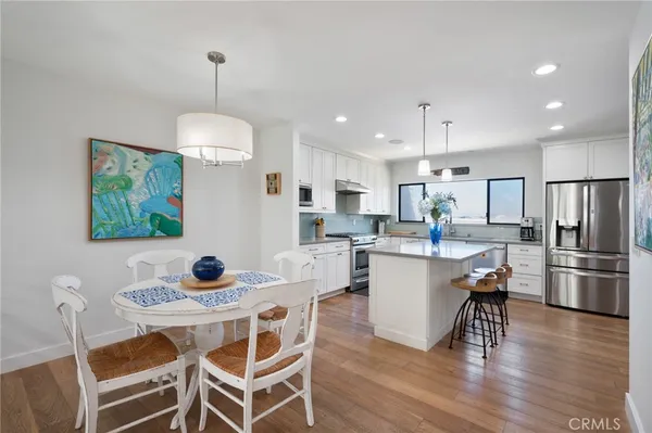 a kitchen with kitchen island white cabinets and stainless steel appliances