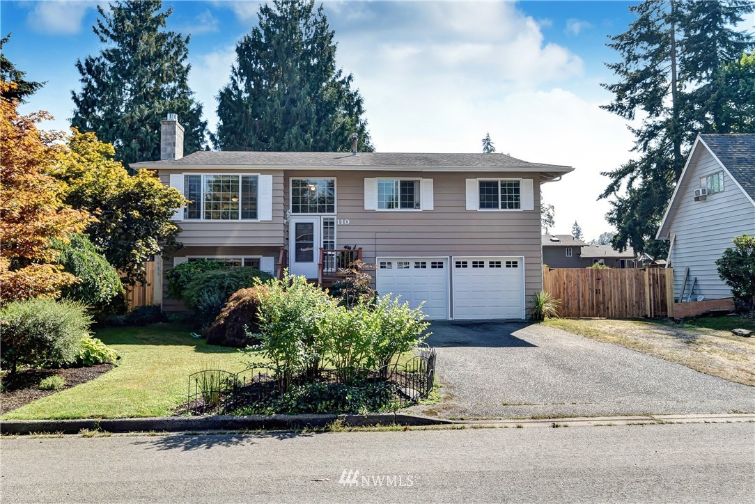 110 217th Place Southeast Bothell, WA 98021 - Photo 1 of 32 a front view of a house with a yard and garage