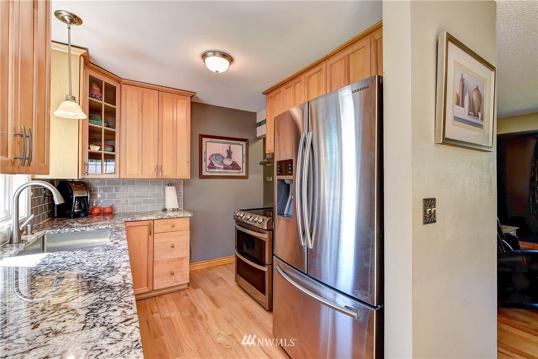 110 217th Place Southeast Bothell, WA 98021 - Photo 13 of 32 a kitchen with stainless steel appliances granite countertop a refrigerator and a sink