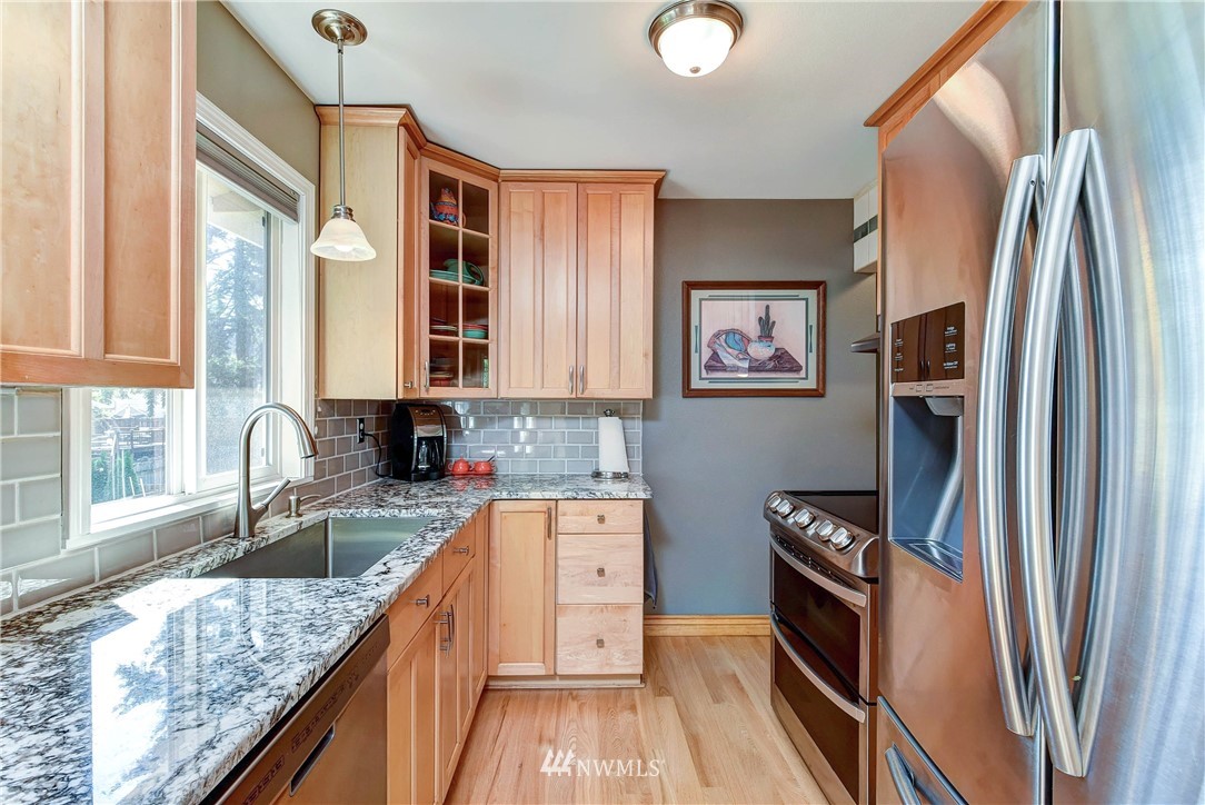 110 217th Place Southeast Bothell, WA 98021 - Photo 14 of 32 a kitchen with stainless steel appliances granite countertop a refrigerator and a sink