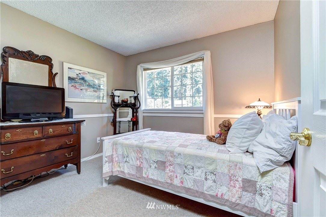 110 217th Place Southeast Bothell, WA 98021 - Photo 18 of 32 a bedroom with a bed and flat screen tv