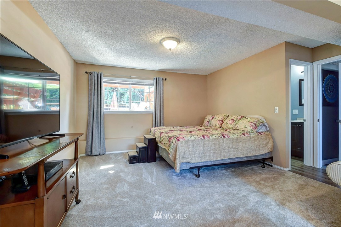 110 217th Place Southeast Bothell, WA 98021 - Photo 20 of 32 a bedroom with a bed and a flat screen tv