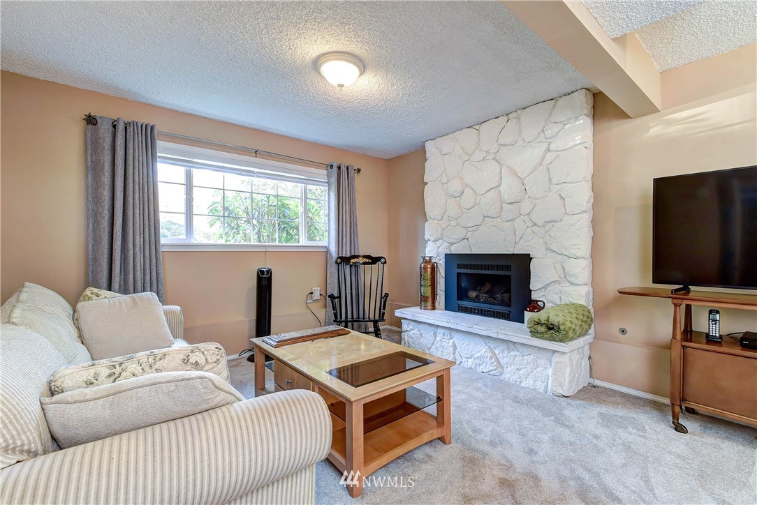 110 217th Place Southeast Bothell, WA 98021 - Photo 21 of 32 a living room with furniture a flat screen tv and a fireplace
