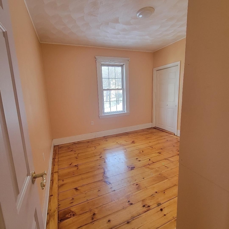 111 Rodney Street, Unit 2 Worcester, MA 01605 - Photo 6 of 9 an empty room with wooden floor and window