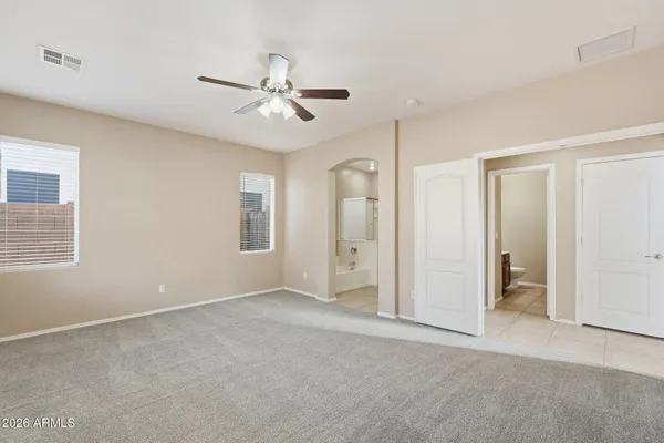 an empty room with closet and fan