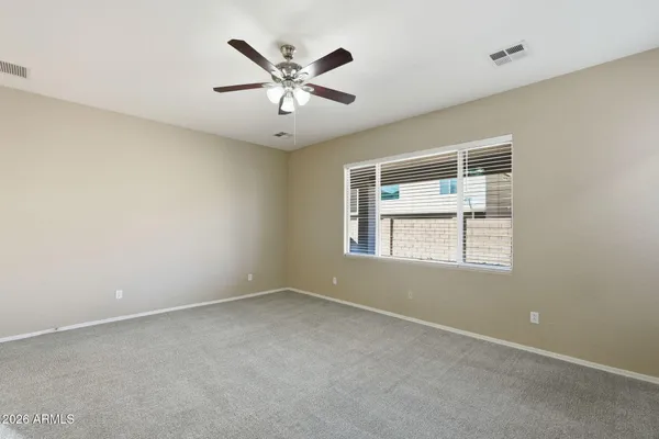 an empty room with a window and a fan