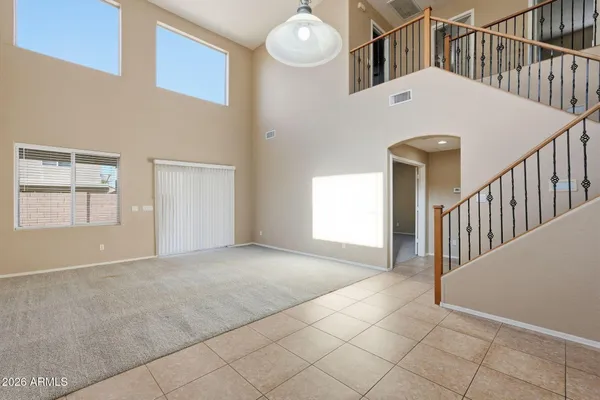 a view of a big room with staircase and white walls