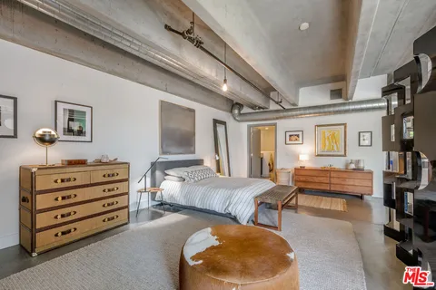 a bedroom with furniture and a large window