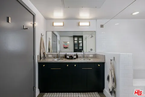 a bathroom with a double vanity sink and a mirror