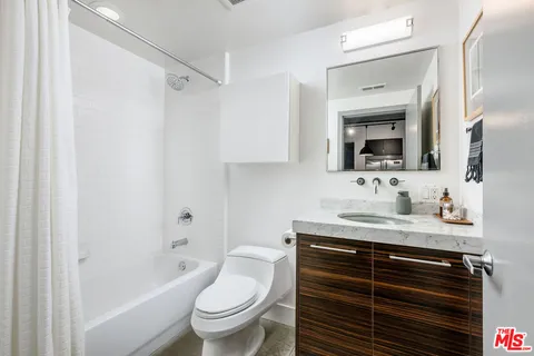 a bathroom with a granite countertop sink toilet and shower