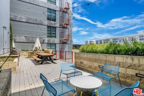a view of a patio with couches table and chairs and potted plants