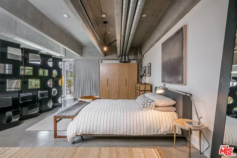 a bedroom with a bed wooden floor and book shelf