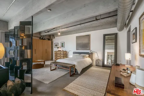 a spacious bedroom with a bed couch and a window