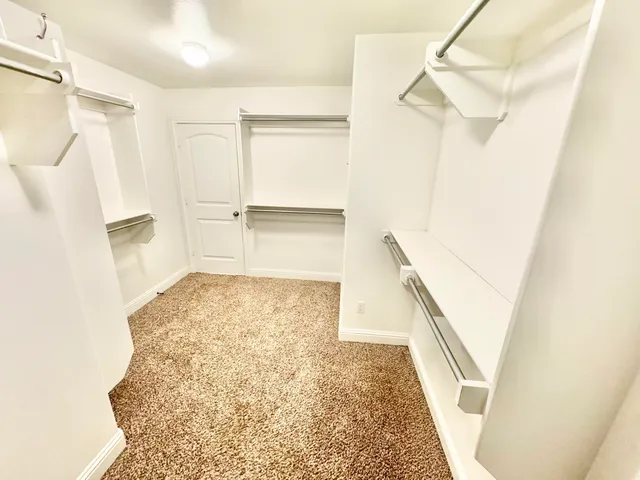 an empty room with wooden floor fireplace and windows