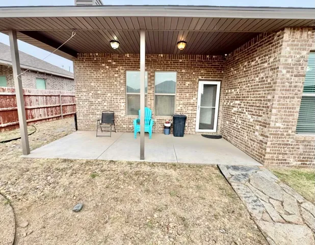 an empty room with windows and fireplace