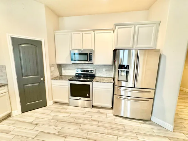 a kitchen with stainless steel appliances a refrigerator stove and microwave