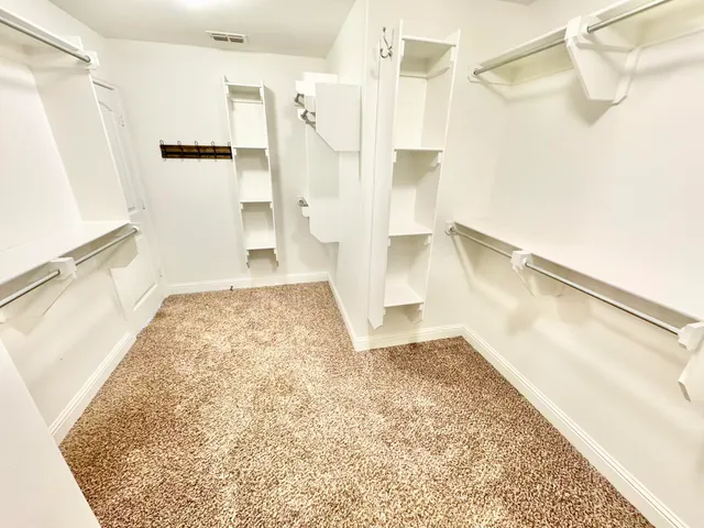 a view of walk in closet with empty racks
