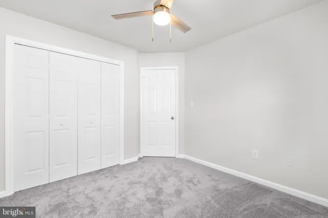 an empty room with a chandelier fan