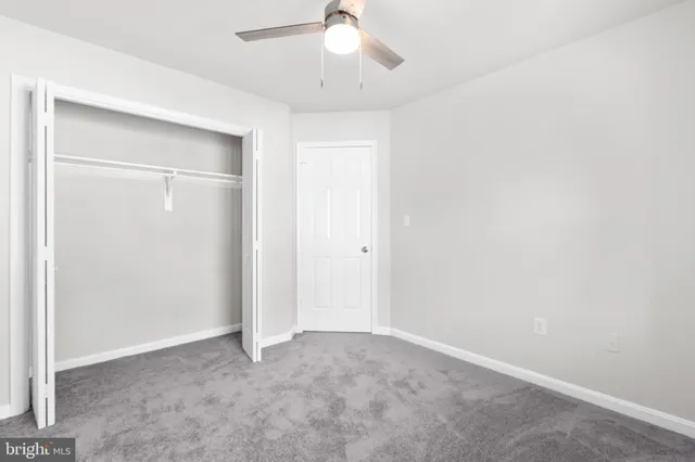 an empty room with a chandelier fan