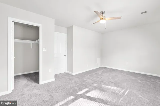 an empty room with fan and a ceiling fan