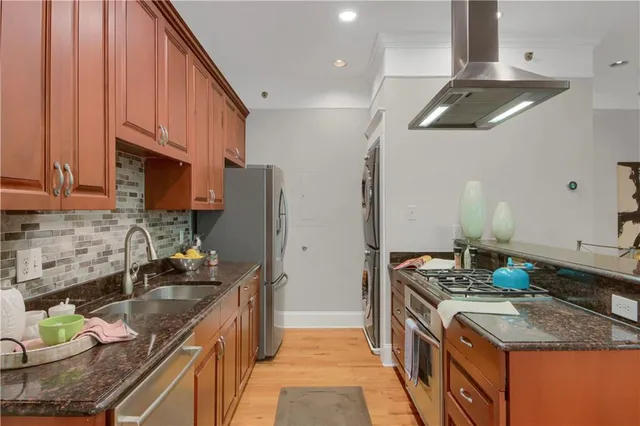 a kitchen with stainless steel appliances granite countertop a sink stove and refrigerator