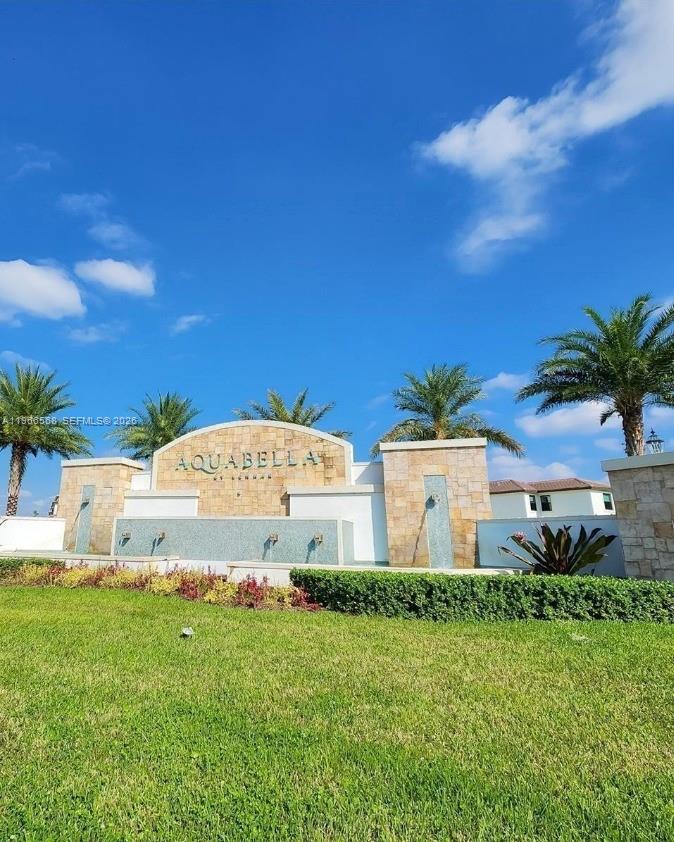 a view of a white house with a big yard and palm trees
