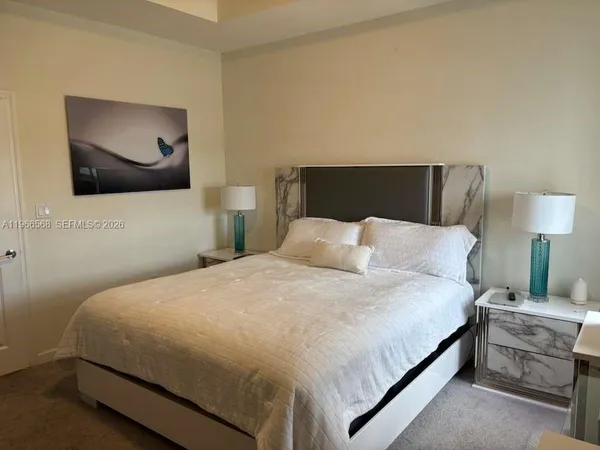 a bedroom with a bed and painting on the wall