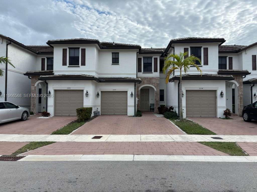 3350 Northwest 112th Street Hialeah, FL 33018 - Photo 4 of 40 a front view of a house with a yard and garage